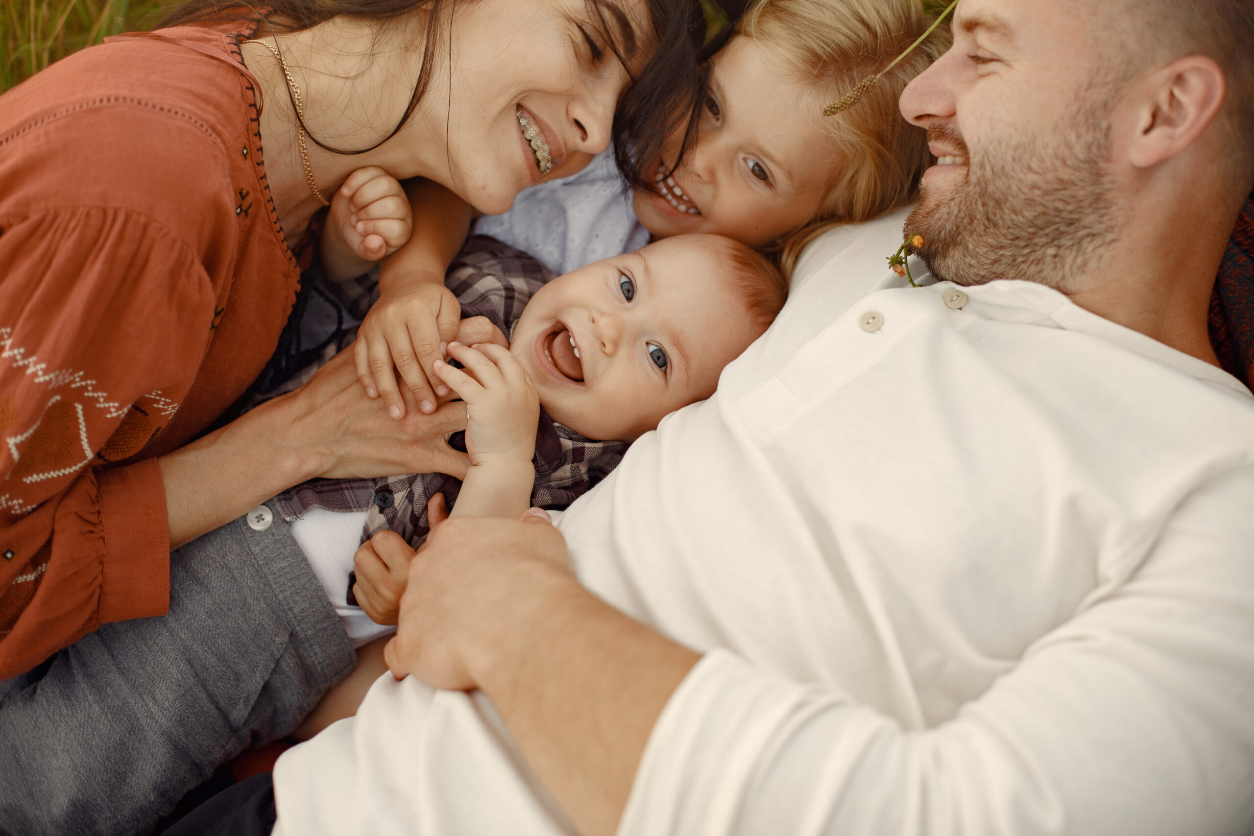 Family with cute little child. Father in a white shirt. Sunset background.